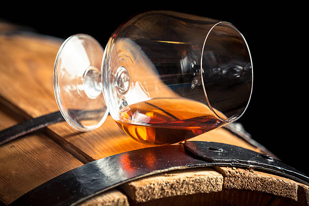 Cognac glass resting on an oak barrel