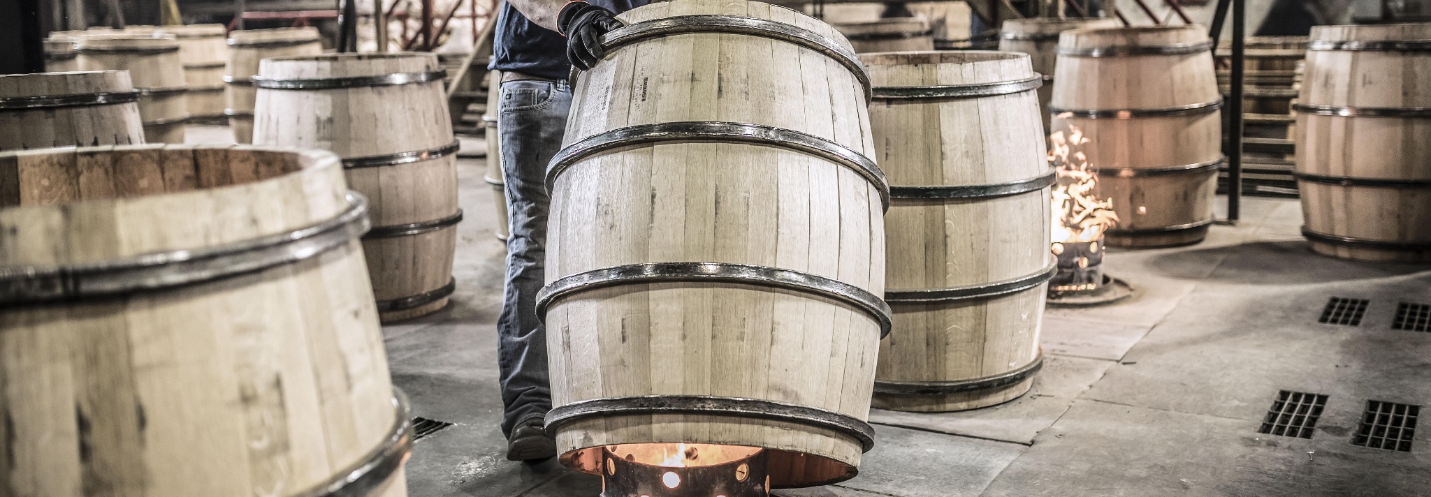 Cooper applying heat to an oak cask during cask preparation